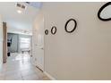 Hallway with sleek tile flooring, neutral paint and circular mirror decor at 13923 Arbor Pines Dr, Riverview, FL 33579