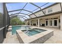 Screened-in pool area features a pool, spa, and covered patio, perfect for outdoor relaxation and entertainment at 19810 Prince Benjamin Dr, Lutz, FL 33549