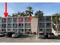 Exterior of a building with a parking lot, palm trees, and an arrow pointing to the featured condo unit at 2077 Canal Dr # L35, Bradenton, FL 34207