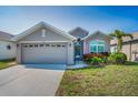 Charming home featuring a well-manicured lawn, front garden, and a two-car garage at 2344 Pleasant Hill Ln, Holiday, FL 34691