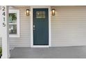 Close up of a light blue front door with the house number, sidelight and stylish sconces at 2415 E 20Th Ave, Tampa, FL 33605