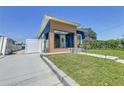 Blue house with modern wooden facade, well-kept lawn, and a concrete driveway leading to a white fence at 2711 W Cordelia St, Tampa, FL 33607