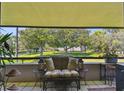 Relaxing balcony featuring a cushioned loveseat, side tables, and an open view of the manicured community grounds at 36750 Us 19 N # 22212, Palm Harbor, FL 34684