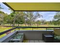 Balcony with comfortable seating overlooks a lush green golf course and trees at 36750 Us 19 N # 22212, Palm Harbor, FL 34684