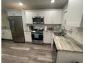 Well-lit kitchen featuring stainless steel appliances and white cabinetry at 4551 Floramar Ter, New Port Richey, FL 34652