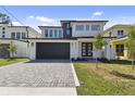 Modern two-story home boasts a dark garage door and a beautifully paved driveway at 6315 S Richard Ave, Tampa, FL 33616