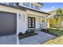 Charming front porch with black framed entry door, custom planters and a brick paved walkway at 6315 S Richard Ave, Tampa, FL 33616