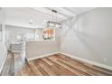 Bright dining area with wood-look flooring and modern light fixture, open to the kitchen at 10407 Westpark Preserve Blvd, Tampa, FL 33625
