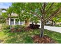 Landscaped front yard with lush greenery and mature trees, creating inviting curb appeal at 11534 Biddeford Pl, New Port Richey, FL 34654