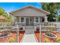 Inviting single-story home featuring stone accents, a charming front porch, and well-maintained landscaping at 1209 E 29Th Ave, Tampa, FL 33605