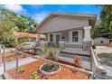 Attractive home boasting a quaint porch, complemented by colorful landscaping and a classic car visible in the background at 1209 E 29Th Ave, Tampa, FL 33605
