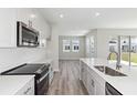 Bright, open kitchen with stainless steel appliances, white cabinets, and large island is perfect for entertaining at 12156 Cattleside Dr, Riverview, FL 33579