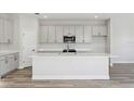 Modern kitchen features white cabinets, stainless steel appliances, large island, and ample countertop space at 12156 Cattleside Dr, Riverview, FL 33579