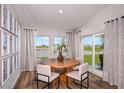 Dining area with a round table, seating for four, and sliding glass doors to the backyard at 14781 Summer Branch Dr, Lithia, FL 33547