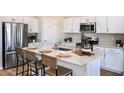 Bright kitchen featuring white cabinets, stainless steel appliances, and an island with seating at 14781 Summer Branch Dr, Lithia, FL 33547