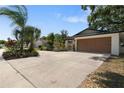 Charming home featuring a well-manicured lawn, beautiful landscaping, and a spacious two-car garage at 1509 Coachlight Way, Dunedin, FL 34698