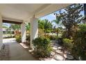 Inviting covered front porch with a landscaped yard, beautiful stone path, and a well-maintained walkway at 1509 Coachlight Way, Dunedin, FL 34698