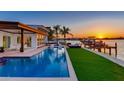 Stunning waterfront home with a luxurious pool and dock overlooking a beautiful sunset view at 16496 Redington Dr, Redington Beach, FL 33708
