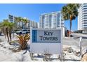 Key Towers sign with lush landscaping, mature palms, and visitor parking at 1750 Benjamin Franklin Dr # 11G, Sarasota, FL 34236