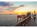 Private boat dock with a lift, providing convenient access to the water and stunning sunset views at 2402 Baywood W Dr, Dunedin, FL 34698