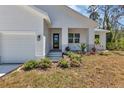 Inviting front entrance with a modern door, well manicured landscape, and covered porch at 2444 Jacobs St, Port Charlotte, FL 33953