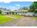 Beautiful home with gray siding, stone accents, a well-manicured lawn, and a paved driveway at 28628 Bennington Dr, Wesley Chapel, FL 33544