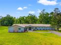 Sprawling ranch-style house with well-maintained landscaping, stone details, and a long drive at 28628 Bennington Dr, Wesley Chapel, FL 33544