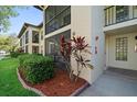 The building's exterior features a beige stucco, a screened porch, and neatly arranged landscaping at 3380 Crystal Court E # G, Palm Harbor, FL 34685