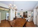 Open dining and living area with chandelier, wood floors, and a view into the kitchen with white appliances at 650 Pinellas Point S Dr # 216, St Petersburg, FL 33705
