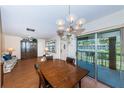 Dining area adjacent to living room with sliding doors to patio and backyard view. Furnished with wooden table at 650 Pinellas Point S Dr # 216, St Petersburg, FL 33705