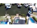 Aerial shot showcasing a home with a screened pool, boat dock, and waterway access at 6505 Bimini Ct, Apollo Beach, FL 33572