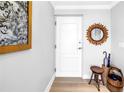 Bright entryway with white paneled door, wooden floors, decorative mirror, and hall tree at 750 4Th Avenue South # 601H, St Petersburg, FL 33701