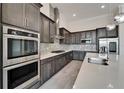Modern kitchen features dark cabinets, stainless steel appliances, and mosaic backsplash at 814 Manns Harbor Dr, Apollo Beach, FL 33572
