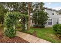 A inviting side view of a home with an arched walkway covered in greenery, offering a sense of peace at 9106 Crystal Commons Way, Tampa, FL 33626