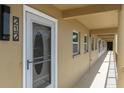 Condo entryway featuring a white door with decorative glass, modern lighting and hallway access at 1 Boca Ciega Point Blvd # 212, St Petersburg, FL 33708