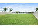 Spacious fenced backyard with lush green grass, boat, landscaping, and view of surrounding neighborhood at 11911 Greenchop Pl, Riverview, FL 33579