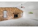 Spacious living room with a stone fireplace and large windows offering natural light at 16139 Villa Dr, Hudson, FL 34667