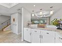 Bright kitchen area with white cabinets, granite countertops, and view into the dining and living area at 170 Ingrid Pl, Oldsmar, FL 34677
