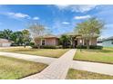 A paved walkway leads to a single-story home with mature trees and freshly cut lawn at 1742 Oakwood Estates Dr, Plant City, FL 33563