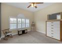 Bright bedroom features shuttered window, neutral carpet, rocking chair and ample storage at 2419 Richmond Greens Ct, Sun City Center, FL 33573