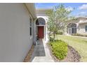 Inviting front entrance features an arched doorway, garden bed and well-manicured lawn at 2419 Richmond Greens Ct, Sun City Center, FL 33573
