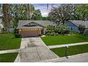 Attractive single-story home featuring a lush front lawn, a two-car garage, and lovely landscaping at 2925 Starmount Dr, Valrico, FL 33596