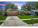 Inviting single-story home with a well-kept lawn, two-car garage, and verdant landscaping at 2925 Starmount Dr, Valrico, FL 33596