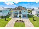 Stunning two-story home featuring a striking blue exterior, manicured lawn, and a spacious driveway with dual garage entries at 3496 Amberjack Dr, Hernando Beach, FL 34607