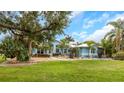 Inviting blue home exterior with a well-maintained green lawn and various palm trees at 424 Island Cay Way, Apollo Beach, FL 33572