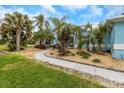 Exterior of home surrounded by green lawn, walkways, and various palm trees, bushes, and plants at 424 Island Cay Way, Apollo Beach, FL 33572