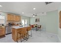 Bright eat-in kitchen with light wood cabinets, stainless appliances, and white marble floors at 439 E Boyer St, Tarpon Springs, FL 34689
