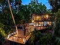Modern house surrounded by lush greenery with expansive decking and outdoor seating at 4701 Rambling River Rd, Brandon, FL 33511