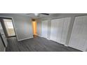 Bright bedroom featuring gray wood floors, closet, ceiling fan, and neutral paint throughout at 4750 Panorama Ave, Holiday, FL 34690