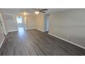 Spacious living room with modern gray wood flooring, ceiling fan, and neutral paint throughout at 4750 Panorama Ave, Holiday, FL 34690